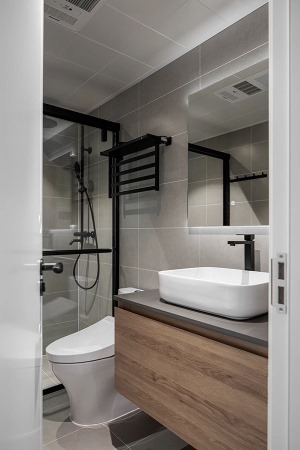 卫生间使用哑光系列的材质来表达空间质感，龙头、毛巾架、花洒选择黑色铜质，和浴室柜门淳朴的木质原色。