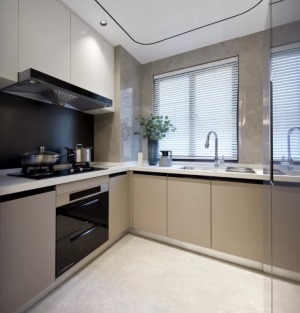 廚房的櫥柜做了U字形的布局，動線設計合理也增強了儲物能力。香檳色的柜門搭配淺灰色的墻地磚。