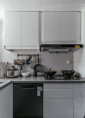 白色橱柜让厨房里的琐碎杂乱得以有序安放，搭配同样浅色系的瓷砖，让空间呈现干净简洁的质感。