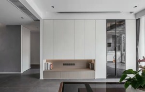 客厅一侧做嵌入式高柜，烤漆门穿插玻璃门设计，视觉上简洁大气。