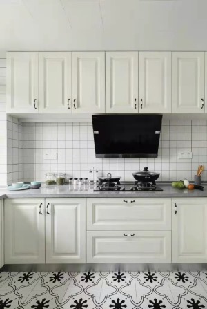 厨房做了一字型橱柜，主色为乳白色显得很干净整洁，地面则用了花纹砖带有美式元素