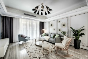 客厅背景墙以浮雕工艺加上金属配饰，黄铜的单人椅与拼接地毯的搭配，时尚简约。
