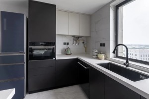 厨房采用U型布局，延伸出一个一体化中岛台，扩宽厨房操作台，又可以衔接餐厅。厨房黑白色的烤漆橱柜，采用