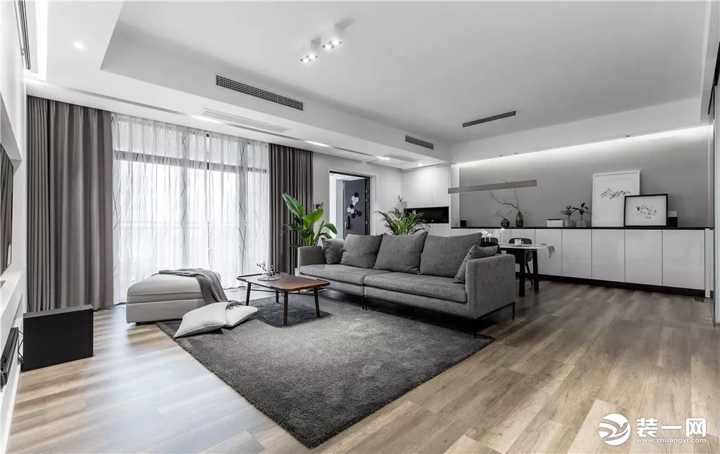 客厅整体选用了现代简约的设计，客厅的面积大，用深灰色的沙发和地毯、窗帘，提高空间层次感。