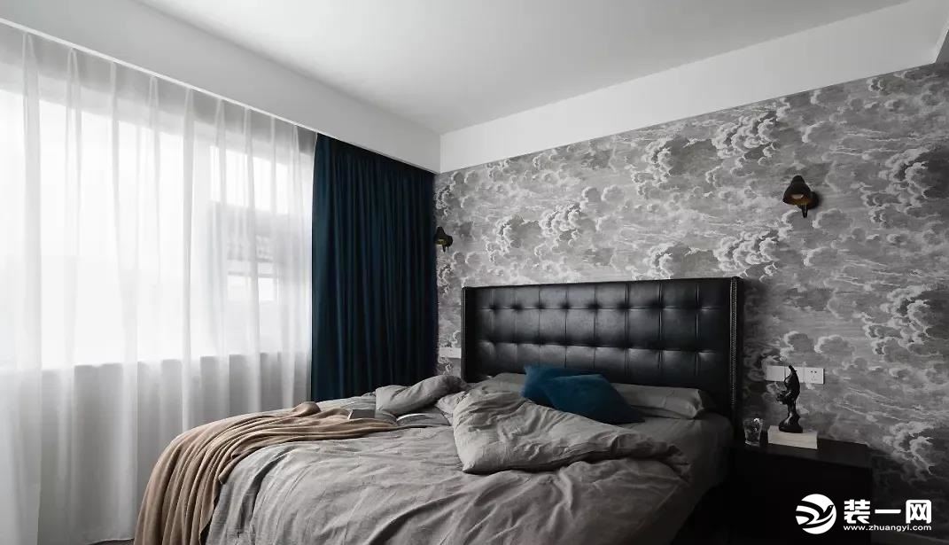 主卧，背景墙采用或深或浅的云层壁纸使其让整个房屋更加的灵动，而且搭配黑色皮质床头及床头柜更是体现了一