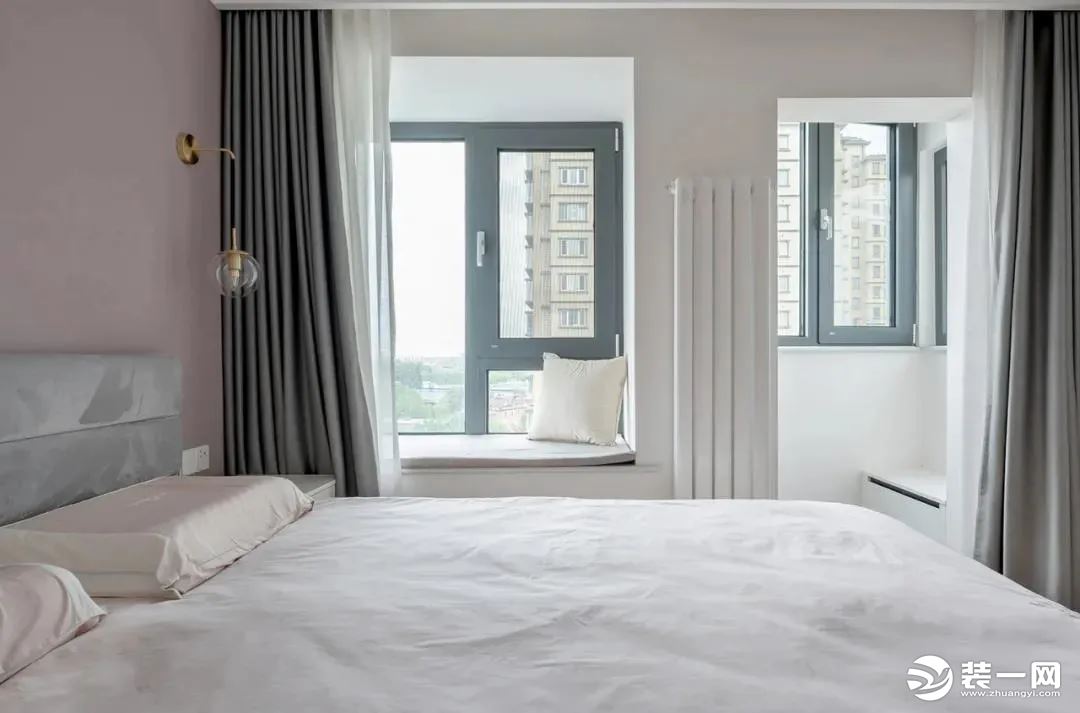 主卧，脏粉色的背景墙+白色的衣柜+柔灰色的窗帘，这三种色调拼接使得整个空间显得静谧而又柔美，还满足了