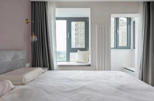 主卧，脏粉色的背景墙+白色的衣柜+柔灰色的窗帘，这三种色调拼接使得整个空间显得静谧而又柔美，还满足了