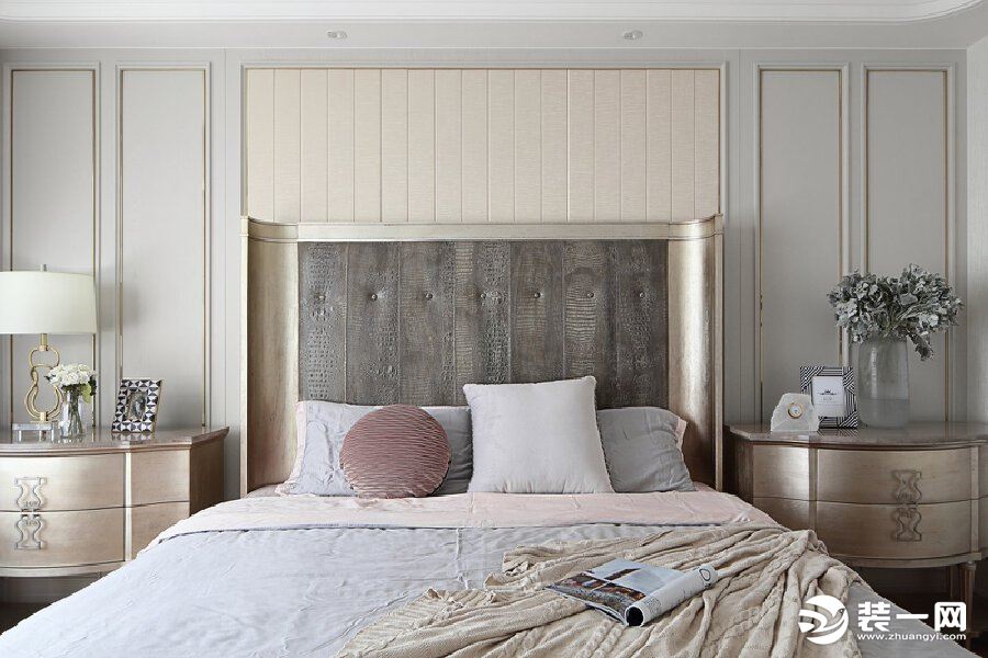 主卧的大床在色调上与背景墙相协调，耳翼造型的床头给人包围感，整体很温馨又显示出独特的时髦感。
