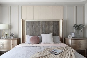 主卧的大床在色调上与背景墙相协调，耳翼造型的床头给人包围感，整体很温馨又显示出独特的时髦感。