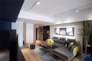 沙发墙挂了三幅抽象墨雅的装饰画，搭配灰黄配的L形布艺沙发，让空间显得儒雅而舒适。