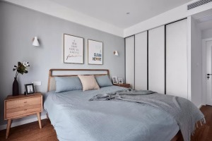 蓝灰色的床头墙与床单，布置木质床与床头柜，床头柜上端庄镜子的花瓶摆饰，让卧室显得优雅禅意好气质。