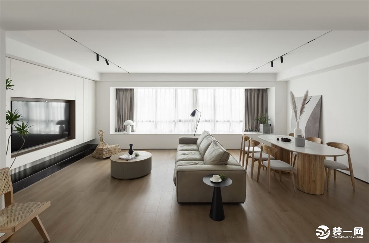 客厅设计简洁干净，尽显轻松、自然、舒适。空间之内，简约的灯饰及电视墙、倚壁而立的装饰画、原木质感的茶