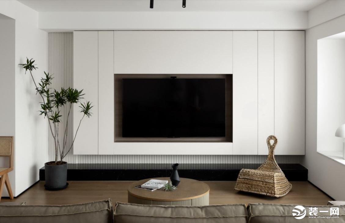  客厅设计简洁干净，尽显轻松、自然、舒适。空间之内，简约的灯饰及电视墙、倚壁而立的装饰画、原木质感的