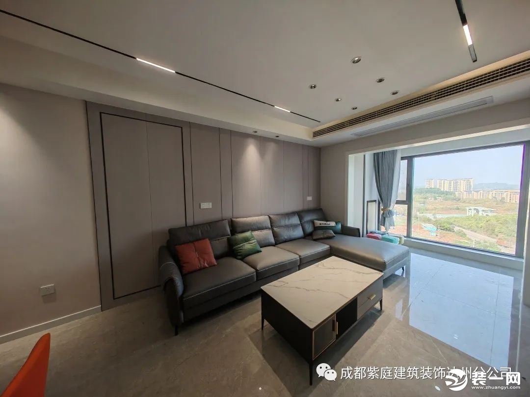 客厅，沙发背景墙用简洁硬包搭配金属线条装饰，让空间更有层次感。