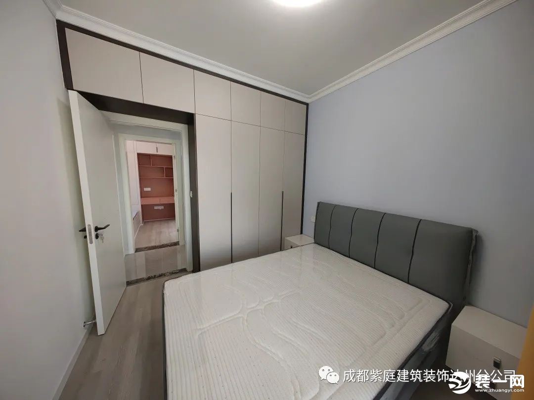 卧室，木质地板和浅色系衣柜、墙面显得休憩空间尤为沉静，  靠墙定制衣柜将空间利用最大化