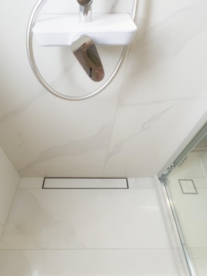 卫生间淋浴区单边坡，单边槽，靠墙加长隐形地漏，体现工艺的精准到位，分毫不差