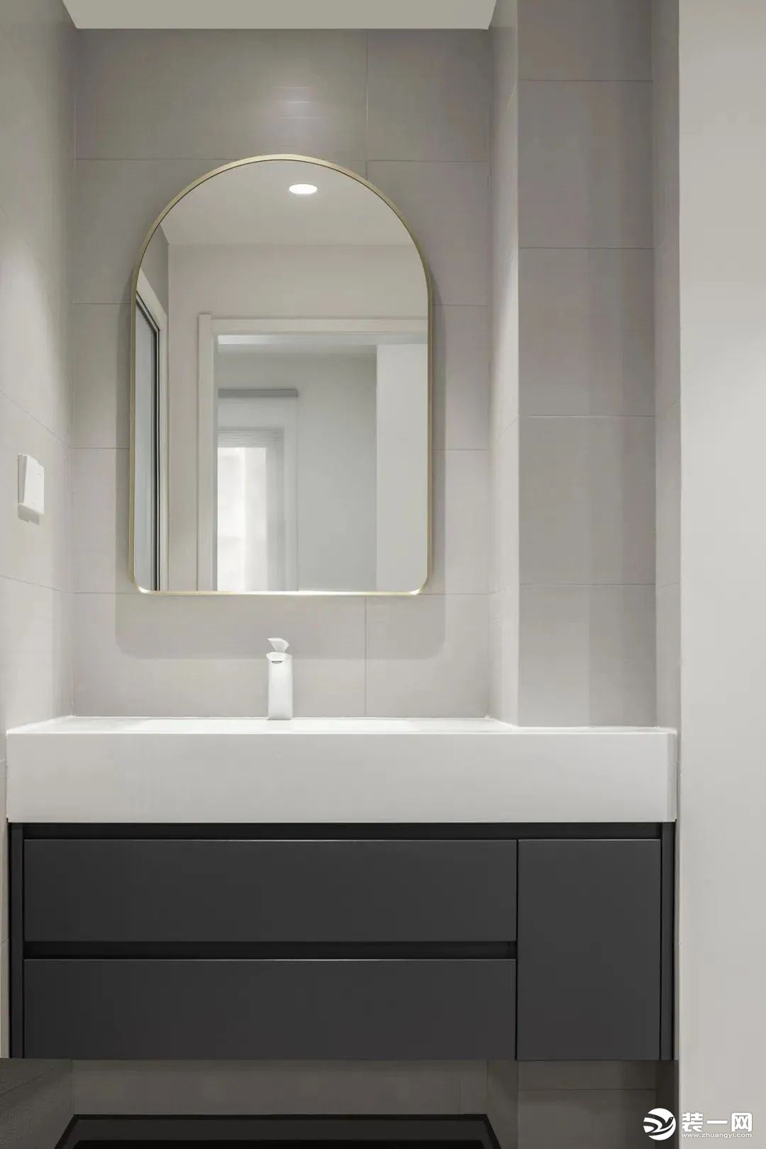 卫生间，以灰白色系为主调，定制悬空灰色台盆柜+白色石英石台面，圆弧形镜子以金属边框勾勒，于细节处带来