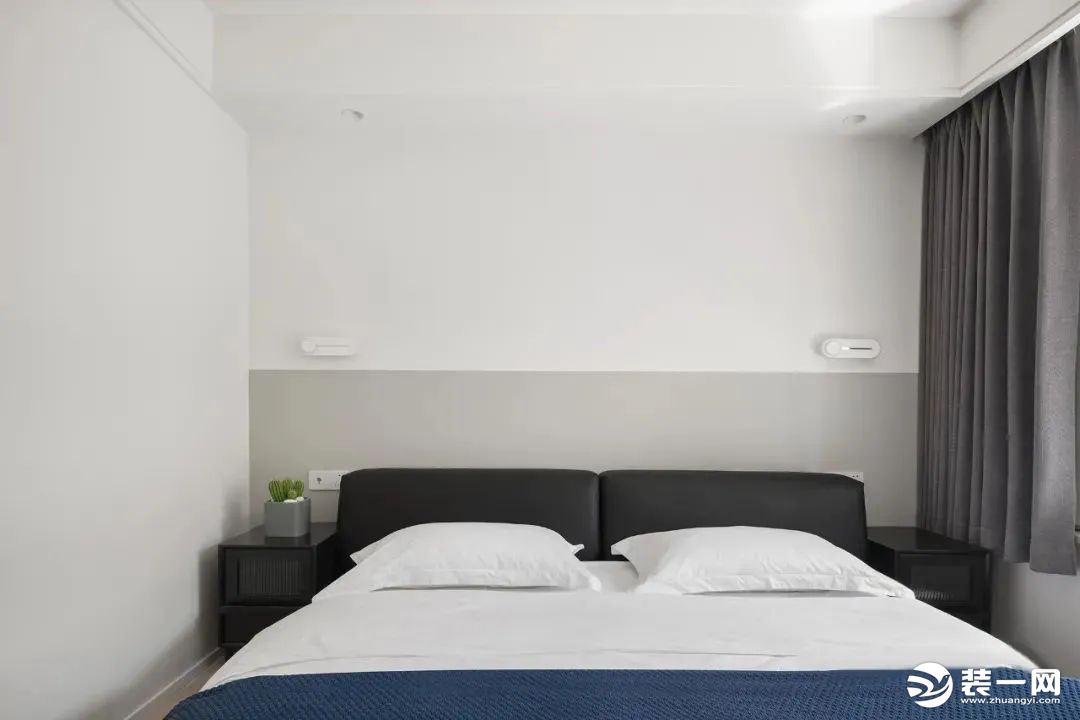 主卧，通过黑白灰的软硬装配色设计，浅灰色分墙设计增添空间层次感，搭配软包黑色床头，带来一个优雅舒适的