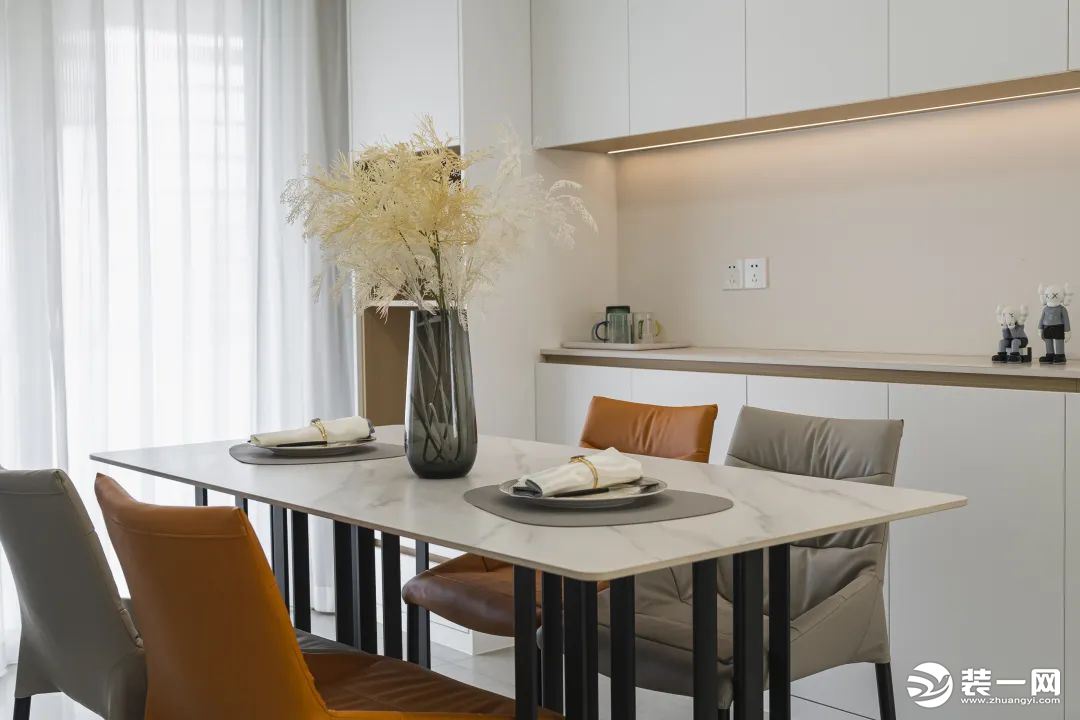 橙灰跳色的餐椅亮丽活泼，辅以干花、绿植装点，营造浪漫优雅的用餐环境。在整体布局上，以最大化的空间陈列
