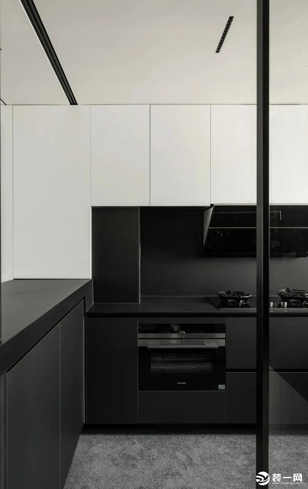 厨房，黑白灰带来强大的视觉张力，摒除表面过多的装饰，深灰色橱柜+白色吊柜搭配，结合吧台的U型布局设计
