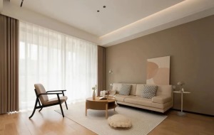卡其色沙發背景墻與木色地面相搭，奶茶色的窗簾搭配紗簾呼應色調、過濾光線，柔軟的淺色地毯襯托，整個客廳