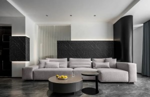 布置灰色布艺组合沙发，雅黑石纹岩板挑空上墙，一面延展留白的意境，插入长虹玻璃营造朦胧的视觉美感，丰富