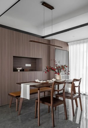 胡桃木色的餐桌椅材质，加上一盏复古简约的一字吊灯，背景打造整面餐边柜，借用原本厨房的空间实现餐厅的宽