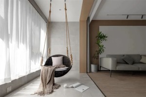 打通阳台与客厅相连接，将阳台打造成休闲娱乐区域，安排一顶秋千吊椅，搭配整面柔和的纱帘，整体在优雅与时