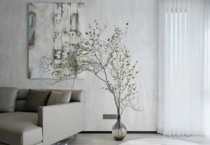 沙发背景墙面素雅的肌理质感，抽象艺术画修饰文艺高雅的空间氛围，串联枝叶的蓬勃生机，连接阳台空间，以竖