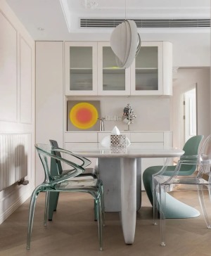 石材餐桌搭配亚克力餐椅，低饱和度的彩色碰撞出浪漫氛围感，沿墙定制餐边柜，柜体做圆弧处理