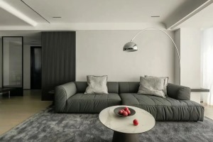 以灰格栅拼接浅灰色壁布，格栅线条将其线性语汇延伸至室内，布置高级灰的皮质沙发，深浅搭配营造出色彩层次
