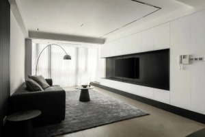 电视背景墙打满白色柜体，提供大量的储物空间，中间留空预留放置电视机位置，黑色背景框架包裹
