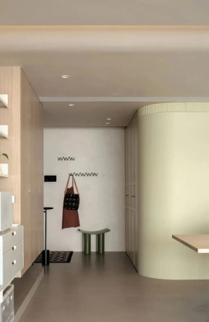 玄关，顶面以弧形柔和过渡错落的层高，奶油色弧体造型墙+悬空原木鞋柜。