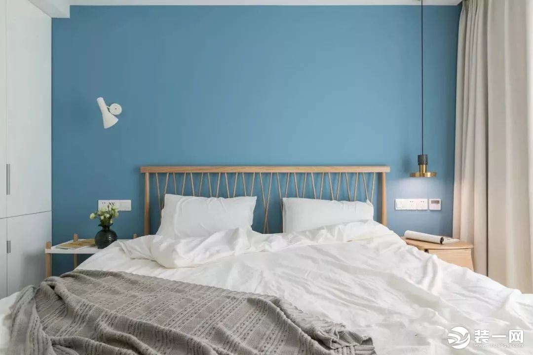 天蓝色的床头背景墙与原木元素的床、床头柜，为整个空间奠定了清新唯美的基调。加上纯色的窗帘与被套点缀，