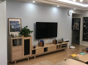 客厅家具多是原木质的，配上灰色的布艺沙发，加上电视桌面装饰和绿植，显得整个客厅温馨朴素又美观雅致。
