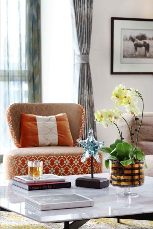 橙赭色几何单椅和地毯占据着空间的大半视线，分明的层次质感营造出浓郁的现代艺术气息