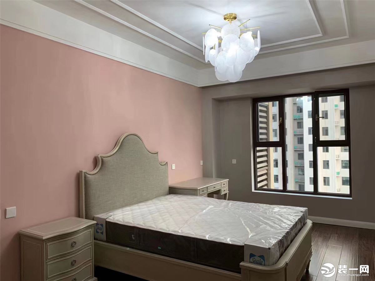 华远枫悦130平美式轻奢风格卧室。淡粉色墙面和床头布艺搭配，整体色调柔和舒适。