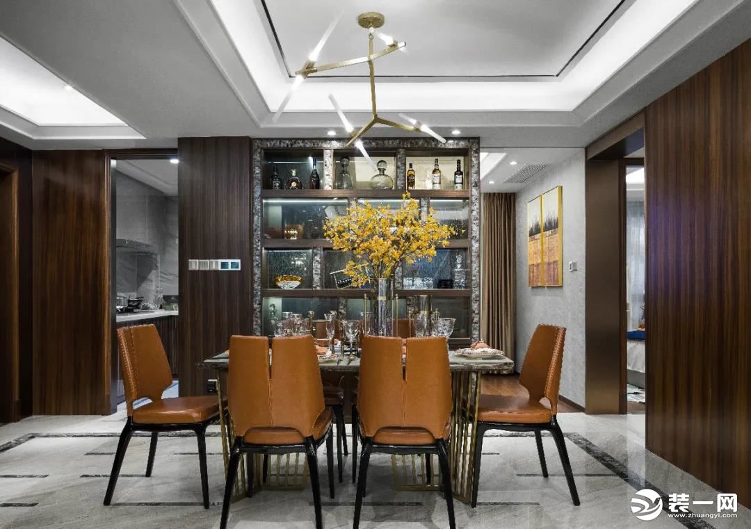 ▲餐厅空间较为宽敞，墙面加入深木色的材质，橙色的餐桌椅组合，餐桌上的跳舞兰装饰，后方定制的酒架收纳，