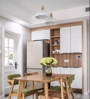 ▲ 木质餐桌椅与养眼的绿搭配起来总是让人心旷神怡，一整面墙的餐边柜装饰性与实用性兼得。
