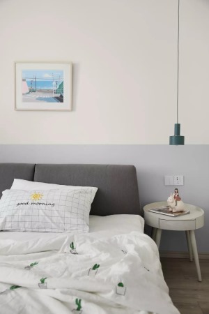 床头背景墙上用灰色乳胶漆做了腰线的设计，和灰色的布艺床头靠背相互呼应，简洁的吊灯和床头柜，让卧室更显