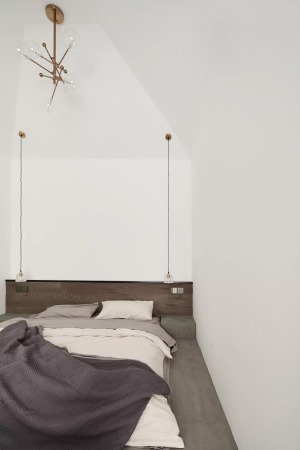 床头垂了两盏长长的吊灯，填补了大面积的空白，小小的点状光源适合打造静谧氛围。床尾是书房区。