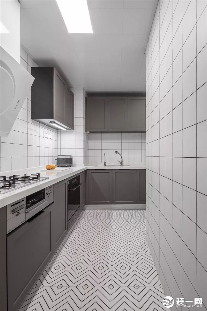厨房以回字形的地面砖搭配白色小格墙面砖，灰色系橱柜质感满满，简约又不失时尚感。
