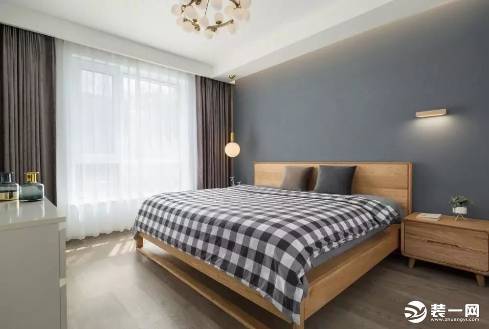  卧室以纯净的灰色为主调，佐以自然温柔的木质床与床头柜，营造安宁静谧的空间氛围。