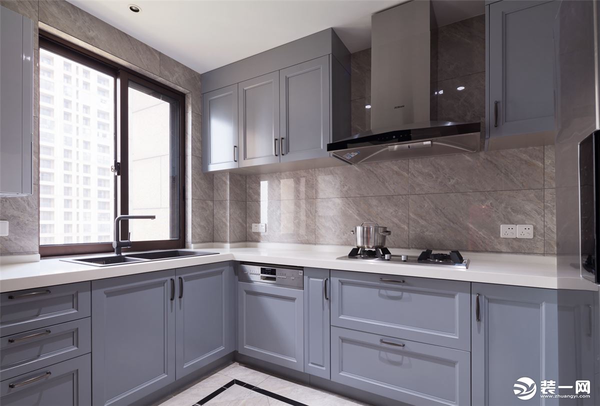 中厨空间是灰蓝色的橱柜搭配白色的台面，整个空间显得清新。
