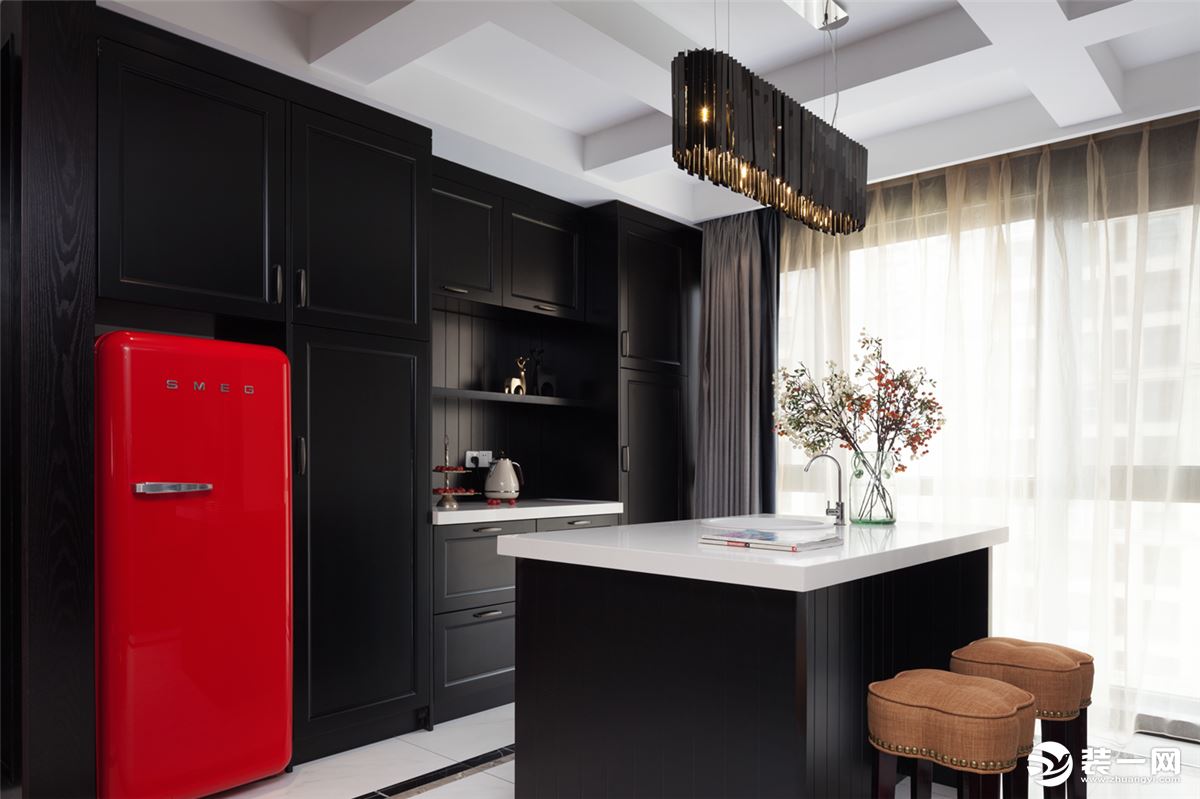 西厨区域，红色的冰箱嵌入黑色的橱柜，时尚又亮眼。  井字形的吊灯造型设计，很有美式风格的特点，黑色的