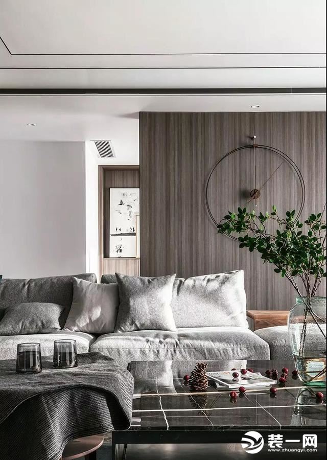 沙发背景用整面的木色木饰面来装饰，在色彩上与电视背景墙形成呼应，线条的纹理让立面的层次也更丰富了；