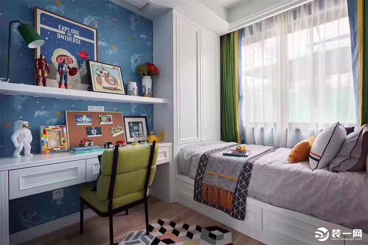 男童房间以蓝色为主打，桌面各种科技相关摆件与背景宇航图相呼应
