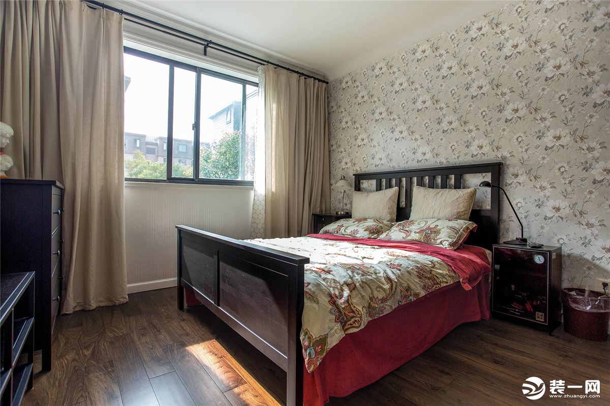 深色的实木地板，白色的实木踢脚线，米色的窗帘，美式复古的双人床，搭配小碎花的床头壁纸，让整个卧室格外