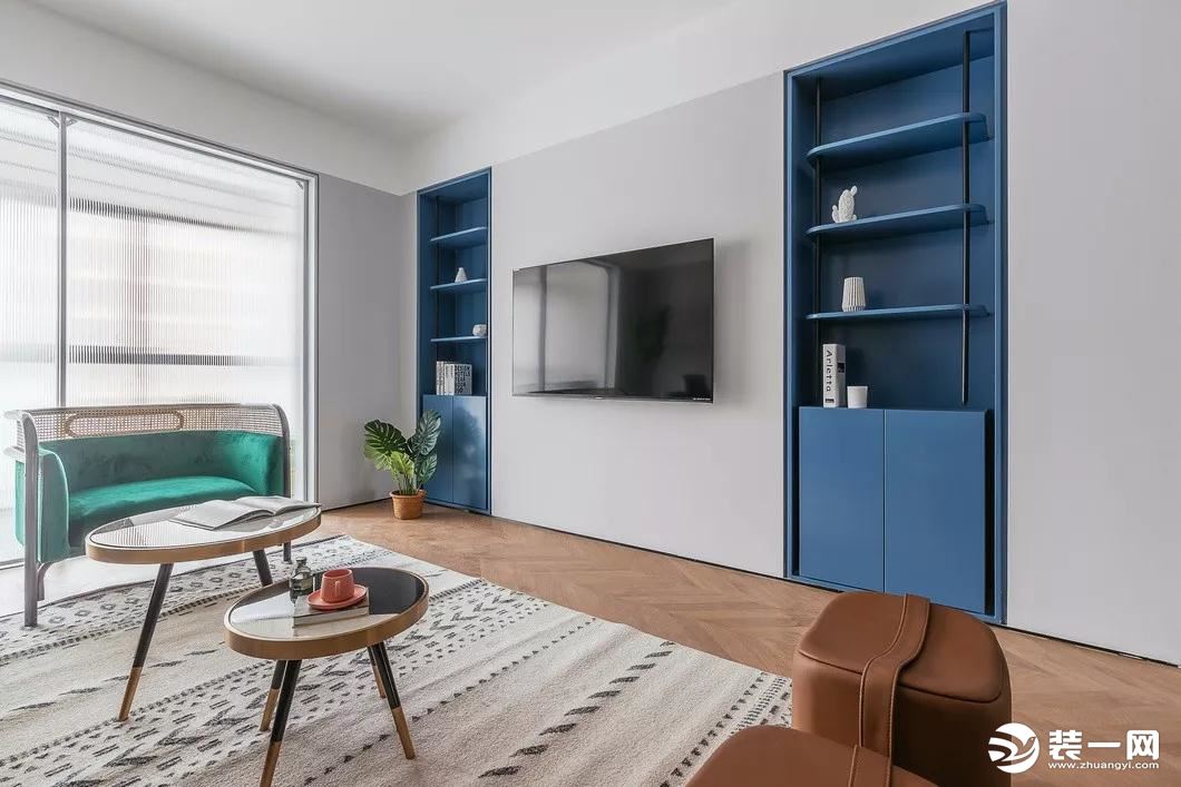 电视背景墙延续简约的风格设计，内嵌式蓝色储物柜特意设计成对称样式，达到平衡整个区域重心的目的。