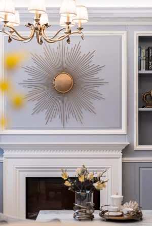 电视墙做了一个壁炉造型，上方是一个太阳造型的铜质墙饰，给客厅空间辐射了热情活力。